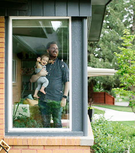 homme avec son bébé dans une maison avec jardin